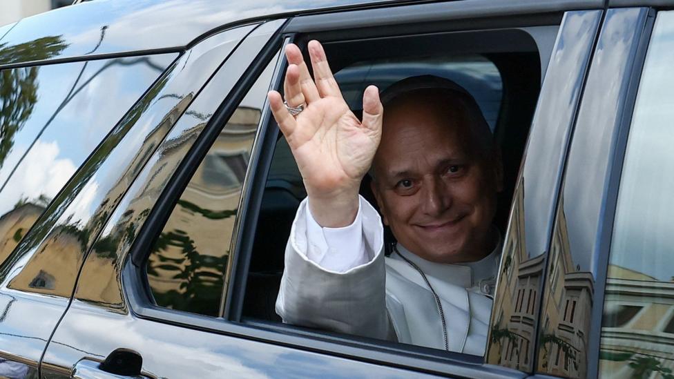 Папа Лев XIV машет из окна автомобиля, покидая университетскую больницу Джемелли в Риме.