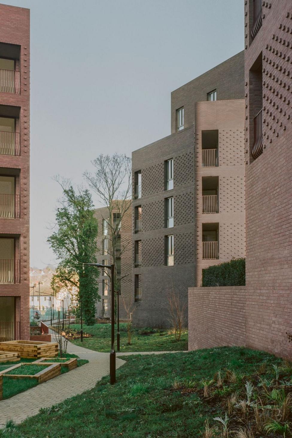 Low rise flats built with purple and pink bricks 