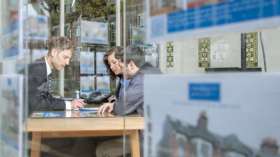 A couple buying a home at an estate agent's office.