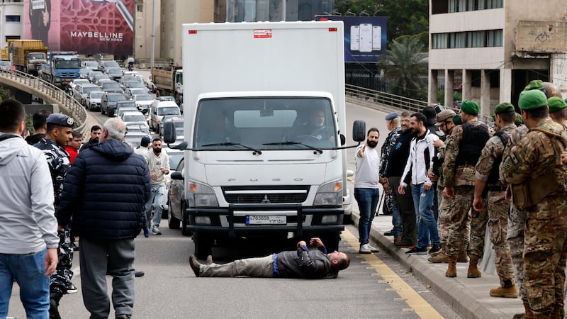 Soliq oshirilishiga va benzin narxlarining oshishiga qarshi namoyish paytida Beyrutdagi yo‘lda taksi haydovchisi yotibdi. EPA