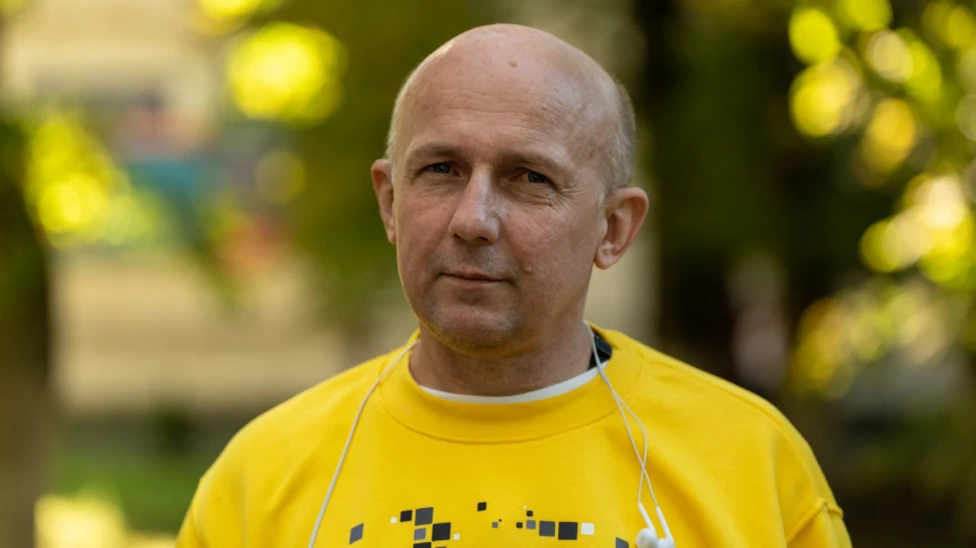 Dmytro Khyliuk, 51, looks directly into the camera in this photo. He is wearing a yellow jumper.