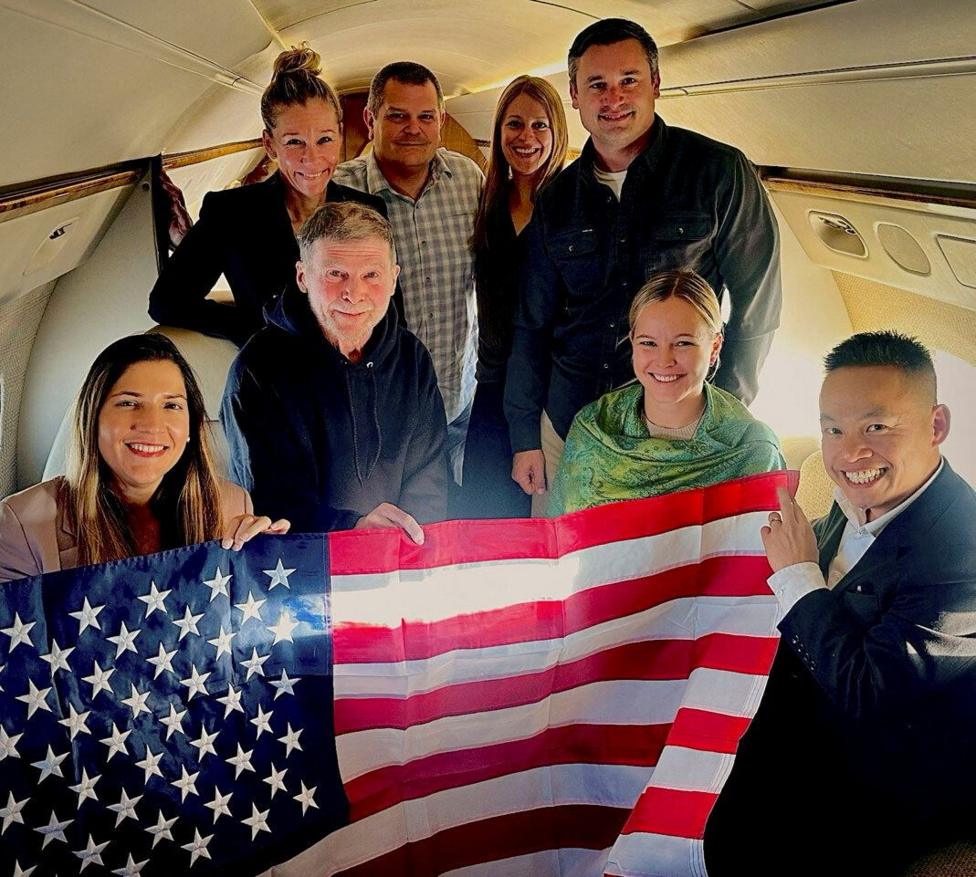 Stephen Hubbard (second from left in the first row) poses with family members and American officials on board a flight to the US after his release from prison. Photo: 21 October 2026