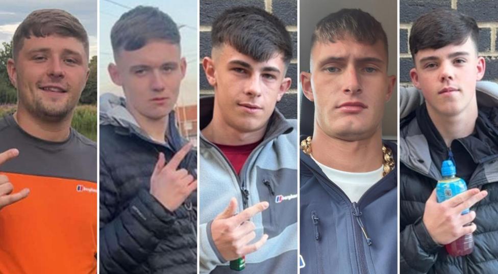 Пятеро молодых людей в возрасте около 18–20 лет. У всех похожие стрижки — с чёлкой и выбритыми затылком и висками. Четверо из них жестикулируют пальцами. Трое выставляют большой, указательный пальцы и мизинец, оставляя средний и безымянный прижатыми. Один показывает указательным и средним пальцами, держа бутылку Lucozade. Все одеты в повседневную одежду.