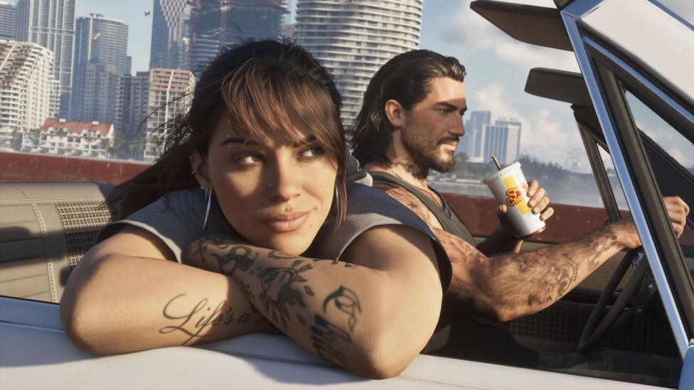 A screenshot from the game GTA 6 featuring the two main characters, Jason and Lucia driving in a convertable car. He is in the background drinking a soda and driving. She is leaning on the inside of the door with her arms crossed. 