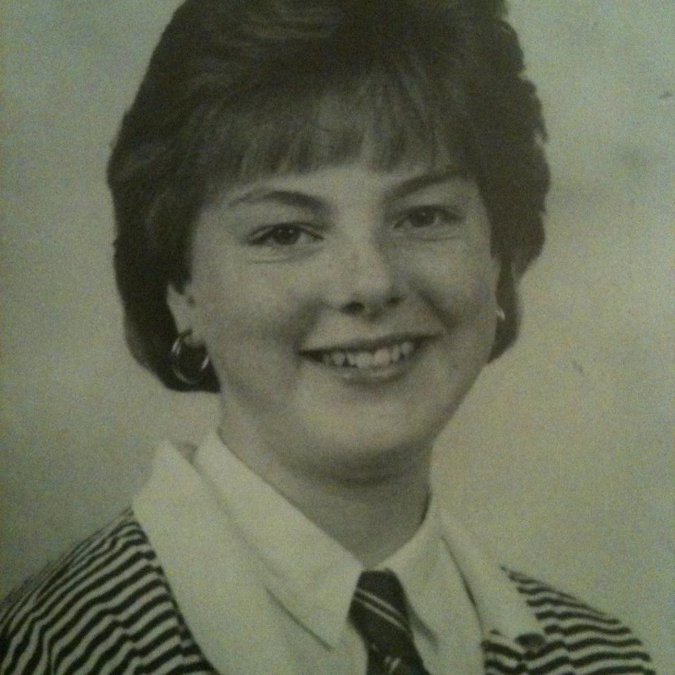 Black-and-white school portrait showing Diane Watson with short hair wearing a striped blazer, white shirt and striped tie, facing the camera against a plain studio background.
