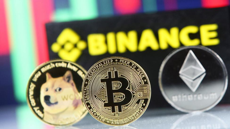 Binance logotipi kriptovalyutalar tasvirlari bilan birga. Arxiv fotosurati
