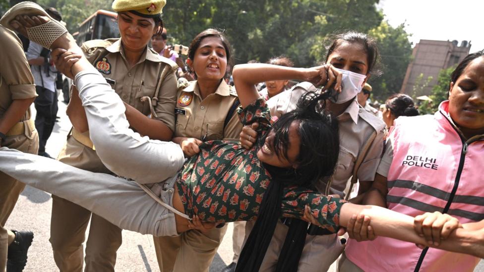 Police personnel detain a supporter of the Cockroach Janata Party (CJP) during a protest demanding the resignation of India's Chief Election Commissioner Gyanesh Kumar over alleged voter roll irregularities linked to the "special intensive revision" (SIR), in New Delhi on October 10, 2026.