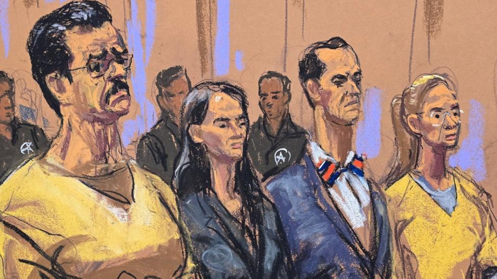 A sketch from court shows Nicolas Maduro and wife Cilia Flores standing with their lawyers between them. They are in prison uniforms and their lawyers, a woman and a man, are in suits.   
