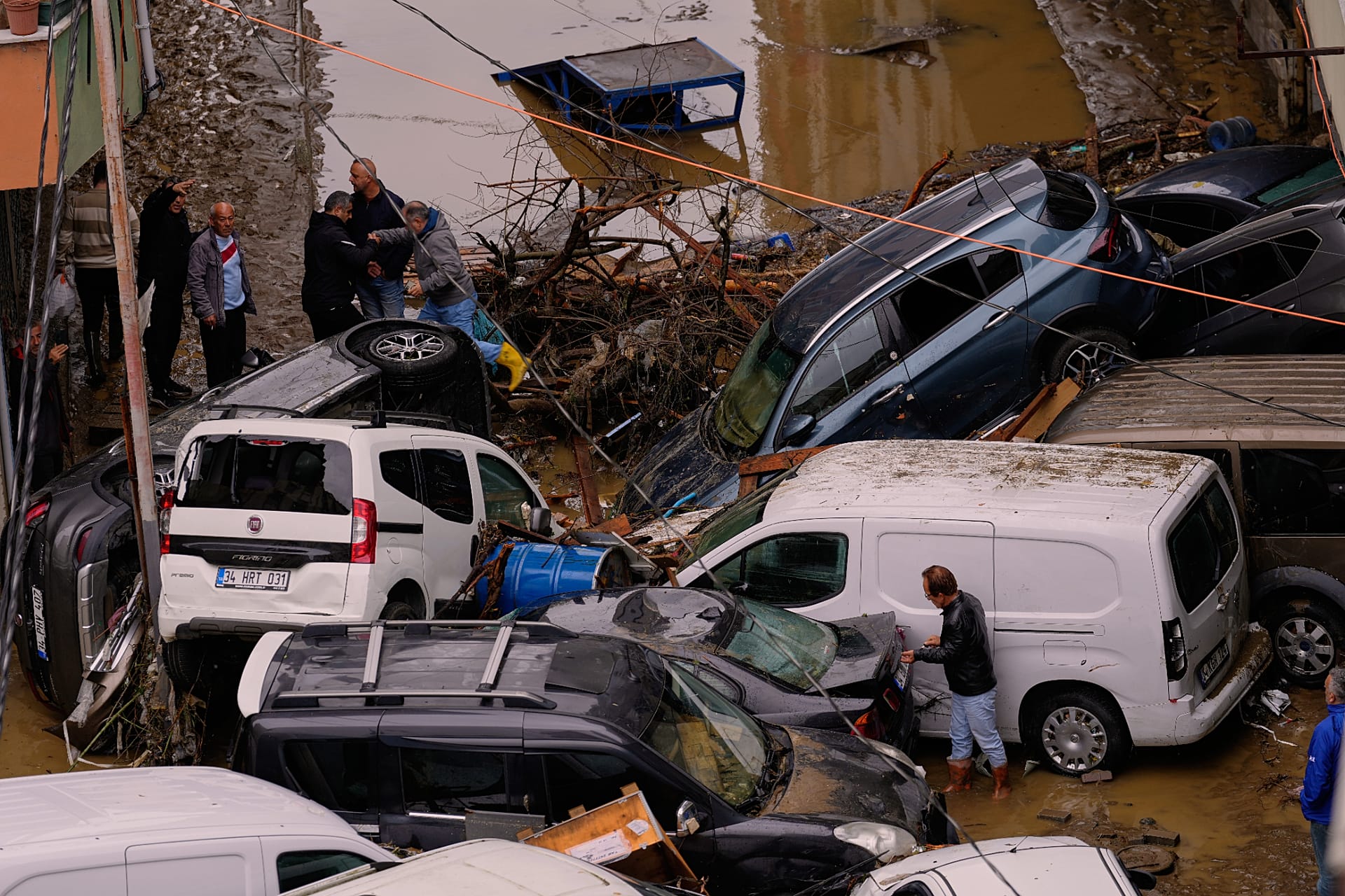 Local residents walk among toppled vehicles and scattered debris in the aftermath of floods caused by heavy rains in Istanbul, 15 October, 2026