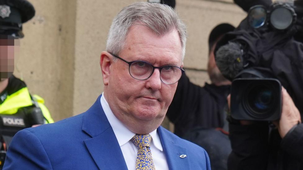 Jeffrey Donaldson, who has short, grey hair and wears glasses, a navy suit jacket over a white shirt and a blue-and-yellow tie.