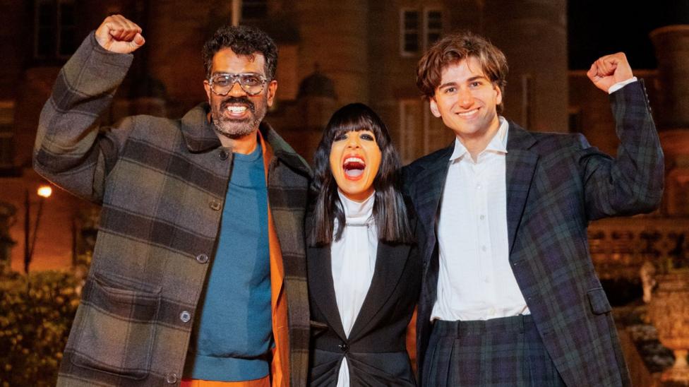Romeş Ranganathan, Claudia Winkleman va Sebastian Croft qöllarini bir-birlarining yelkasiga solib nişonlamoqda