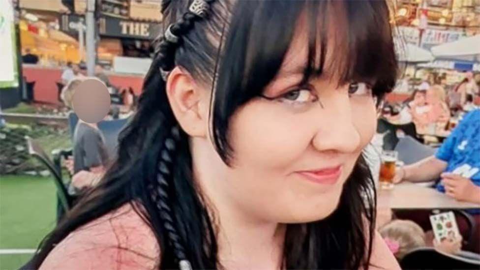 Lily Jones, who has black hair and is wearing a pink top