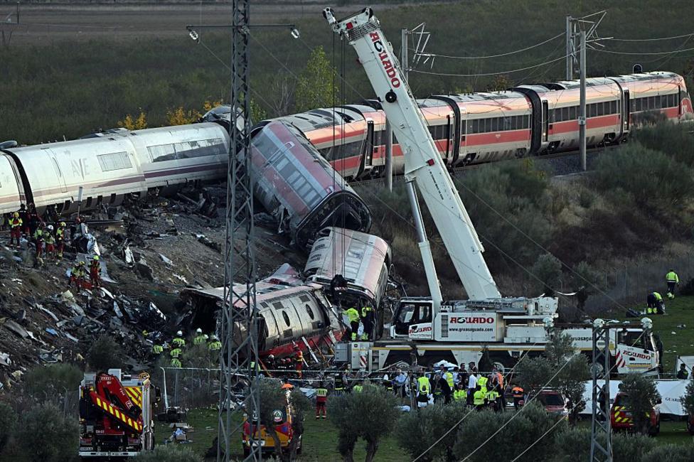 A crane at the site of the train crash near Urda on 28 October. A number of one train's carriages have fallen down a ledge, while other carriages remain on the railway line.
