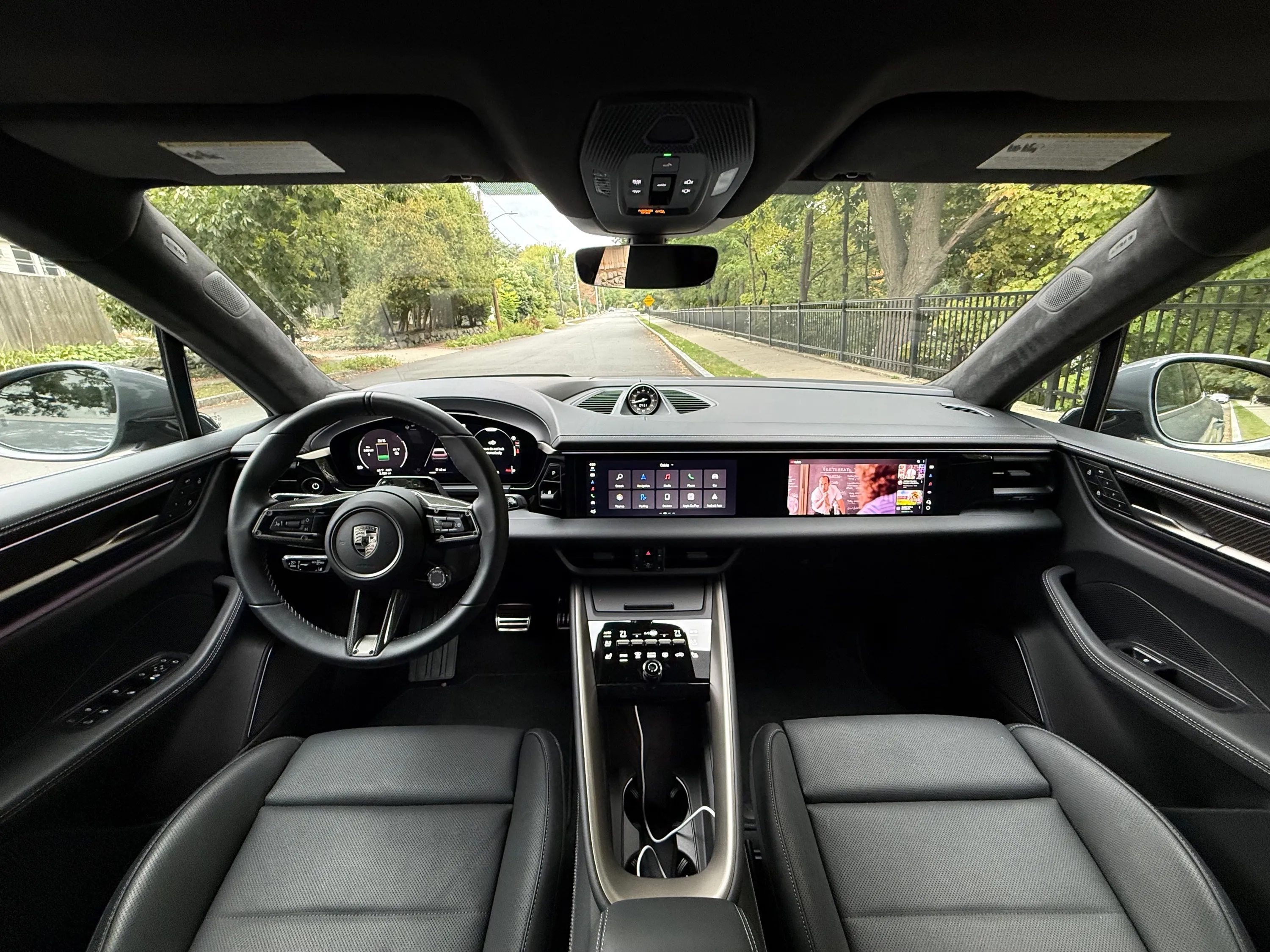 Three screens illuminate the dash of a Macan EV.