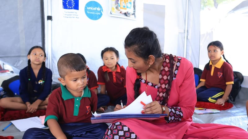 Children sit on the floor as classes are conducted at the makeshift Tribhuvan Trishuli secondary school in Nuwakot, Nepal. Photo: Rajendra Dawadi