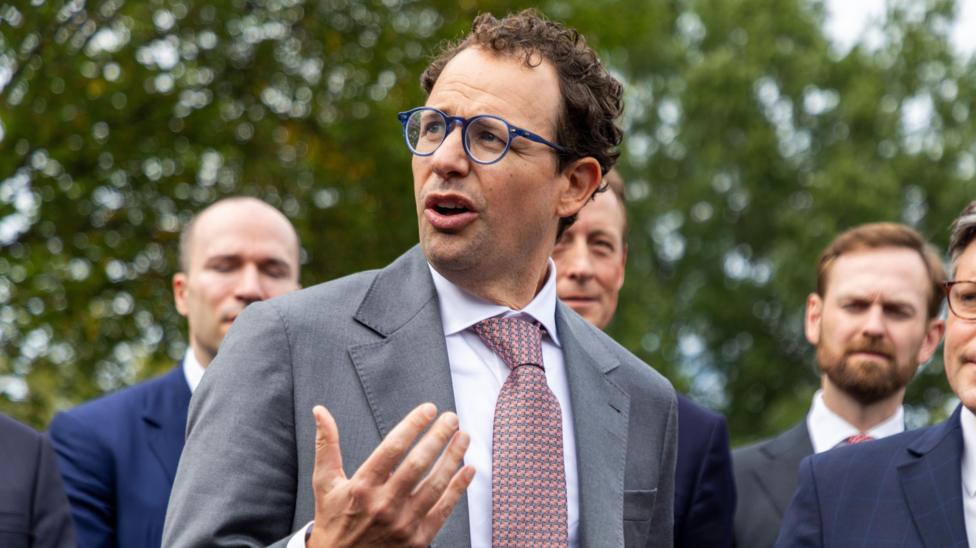 Anthropic CEO Dario Amodei gestures with his hands while speaking to reporters outside of the White House.