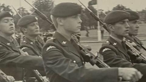 Miltiq bilan yurayotgan Britaniya desantniklarining qora-oq surati.