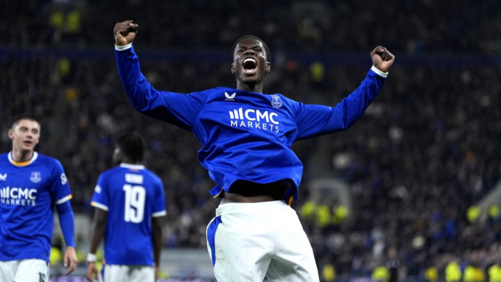Thierno Barry, wearing his blue Everton top and white shorts, roars in delight
