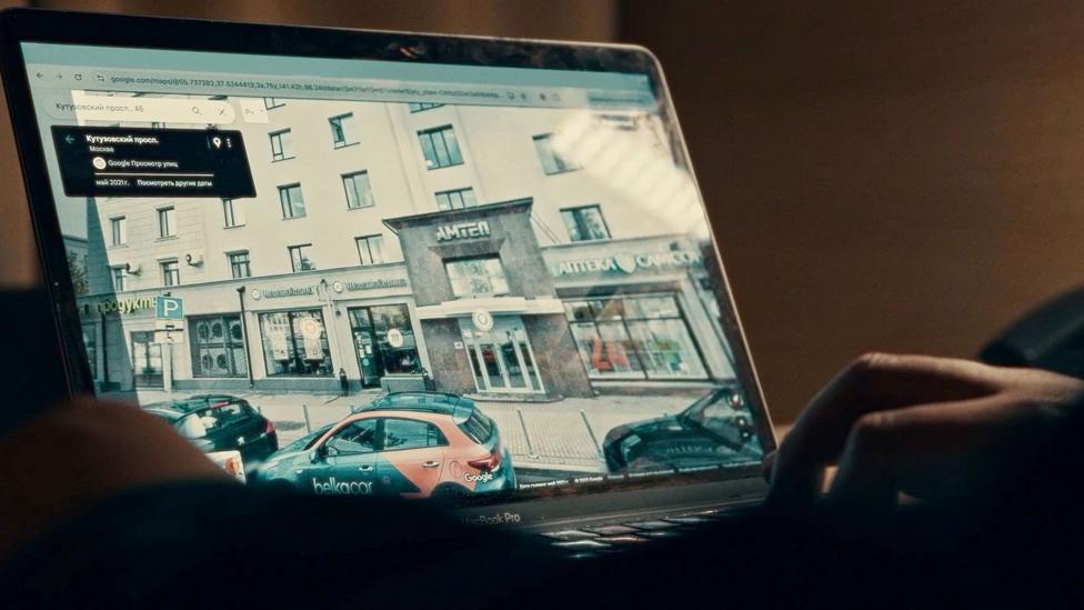 Foma's computer screen, showing buildings and cars in Russia - and his hand on the computer keyboard 