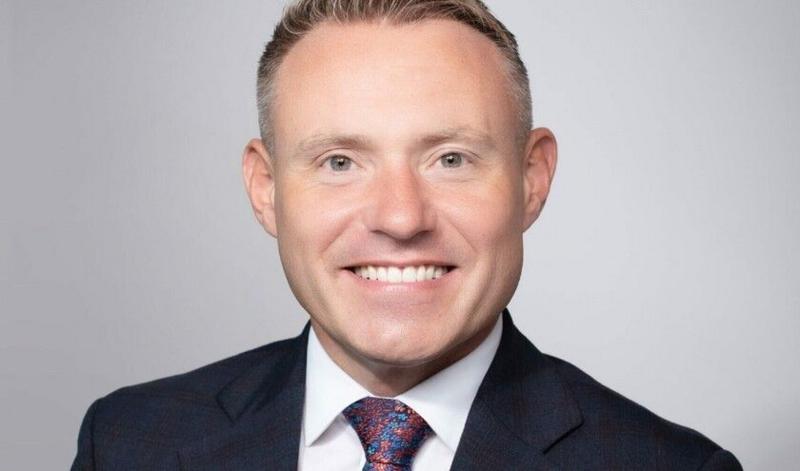 Adam Doyle dressed in a suit jacket, white shirt and tie