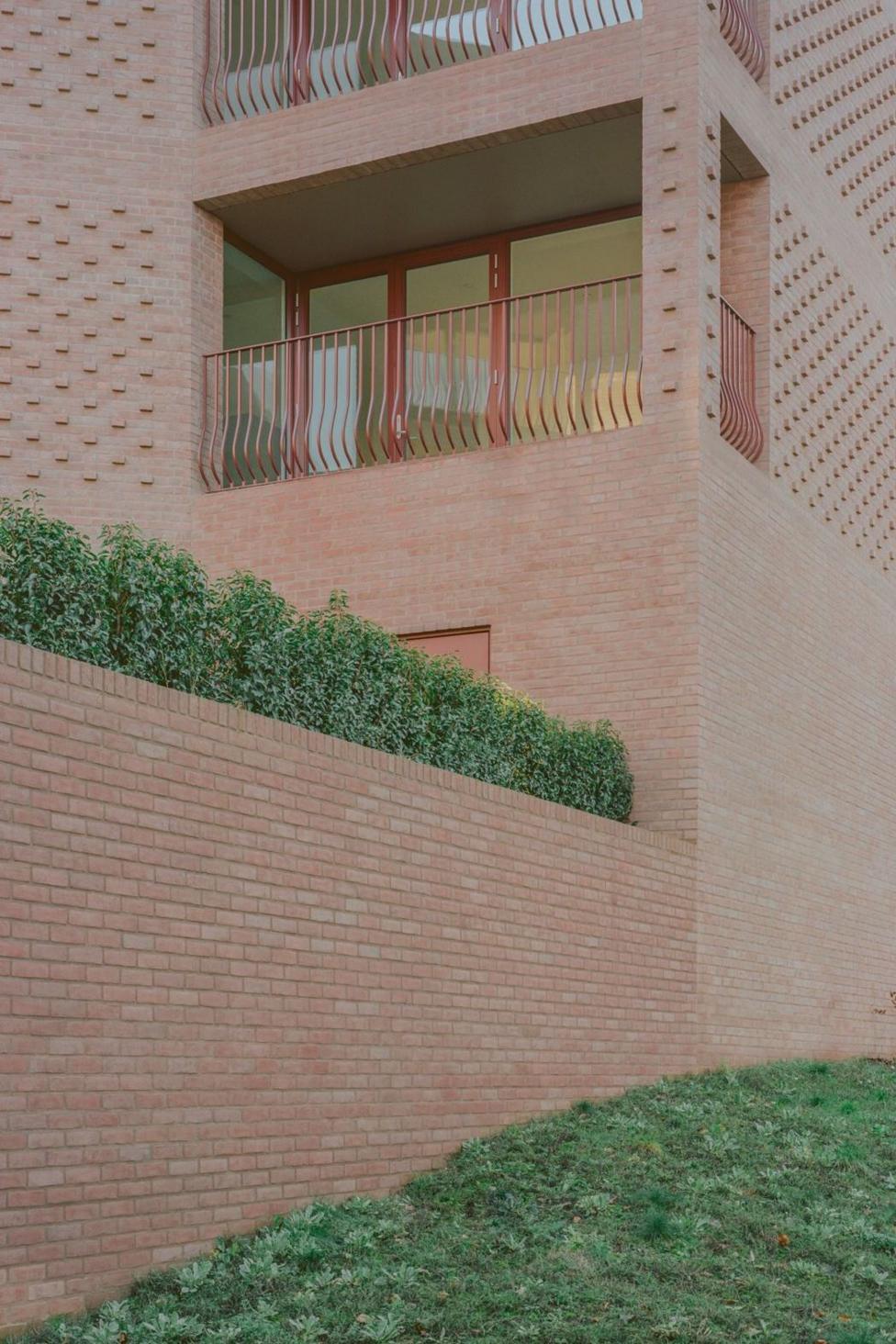 Low rise flats built with purple and pink bricks 
