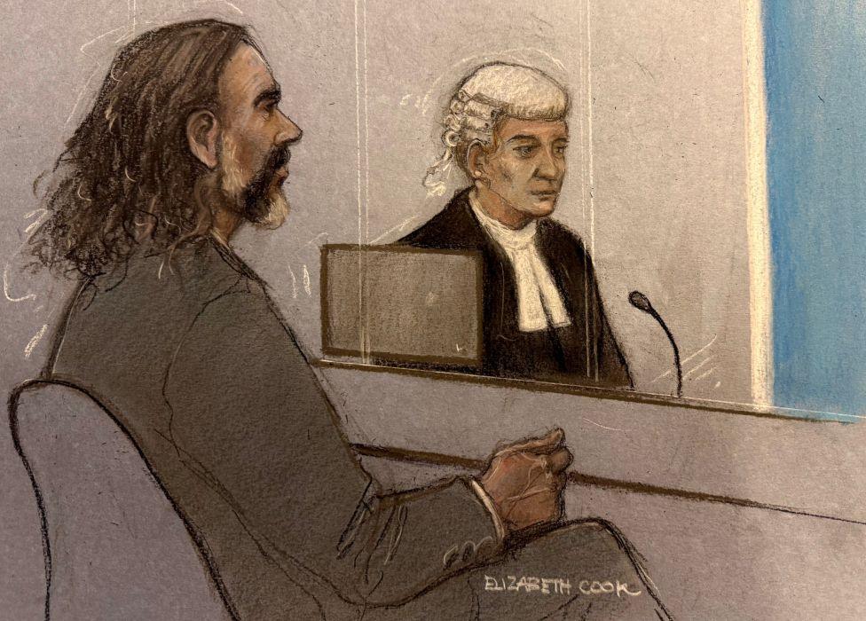 Court artist sketch by Elizabeth Cook of Russell Brand and barrister Riel Carney-Jones KC listening to witness evidence being given from behind the blue screen at Southwark Crown Court, London, where Brand is charged with three counts of rape, indecent assault, and three counts of sexual assault, relating to six women