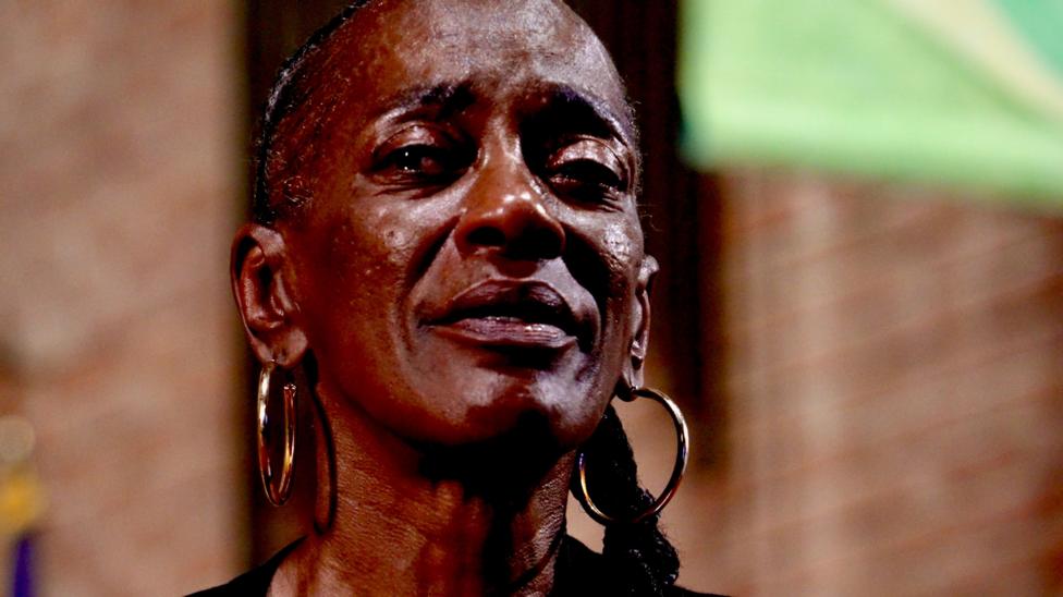 Close-up head shot of Tonya, who looks visibly emotional