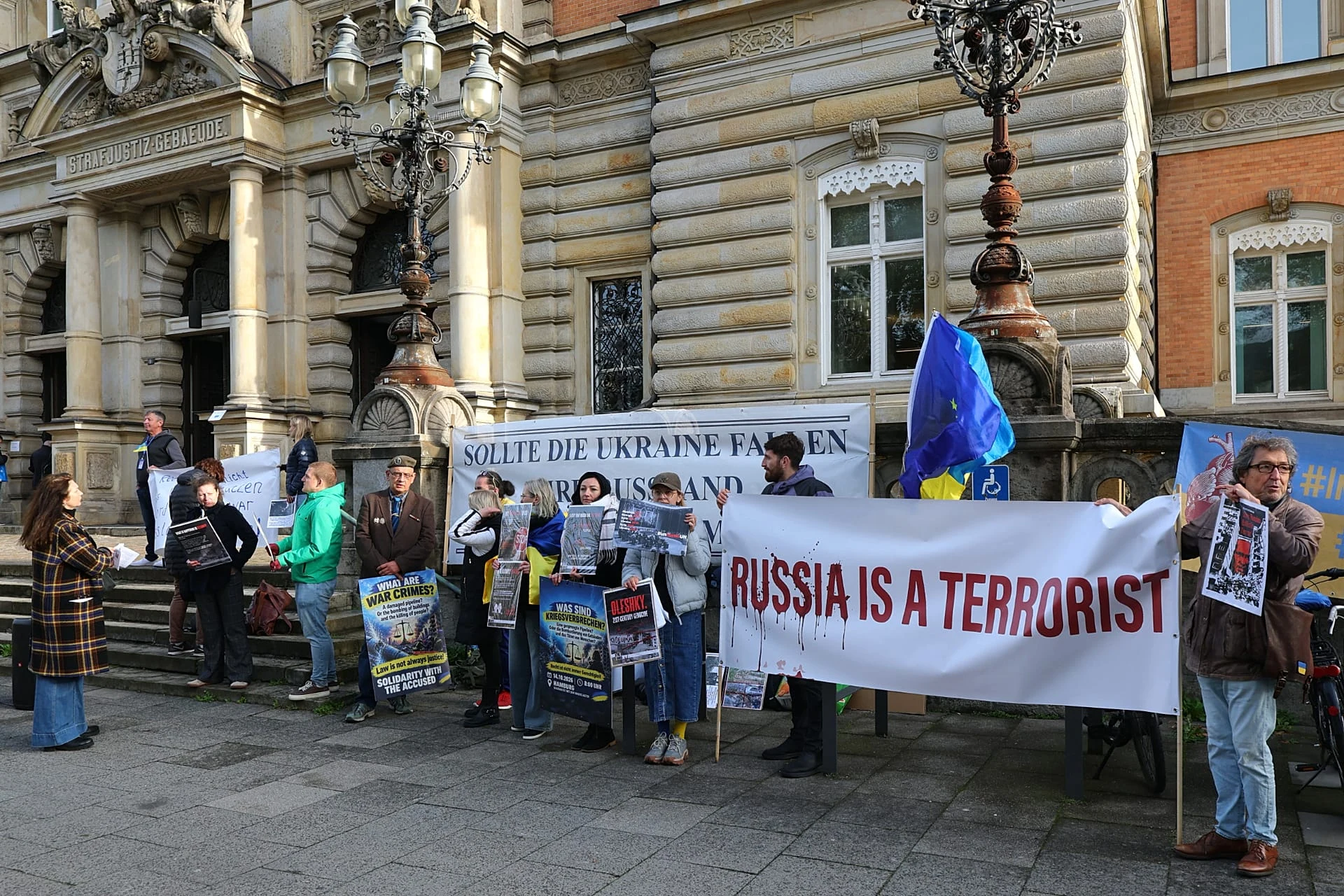 Сторонники Украины собираются у входа в Ганзейский высший земельный суд в Гамбурге, 14 октября 2026 года