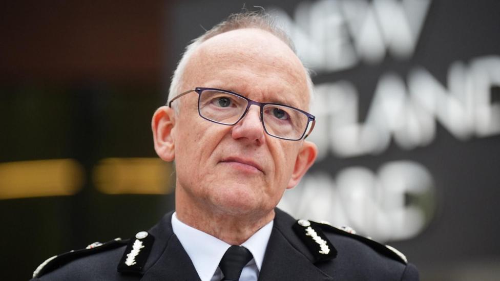 Metropolitan Police Commissioner Sir Mark Rowley stands in front of the New Scotland Yard sign, his head and shoulders in shot