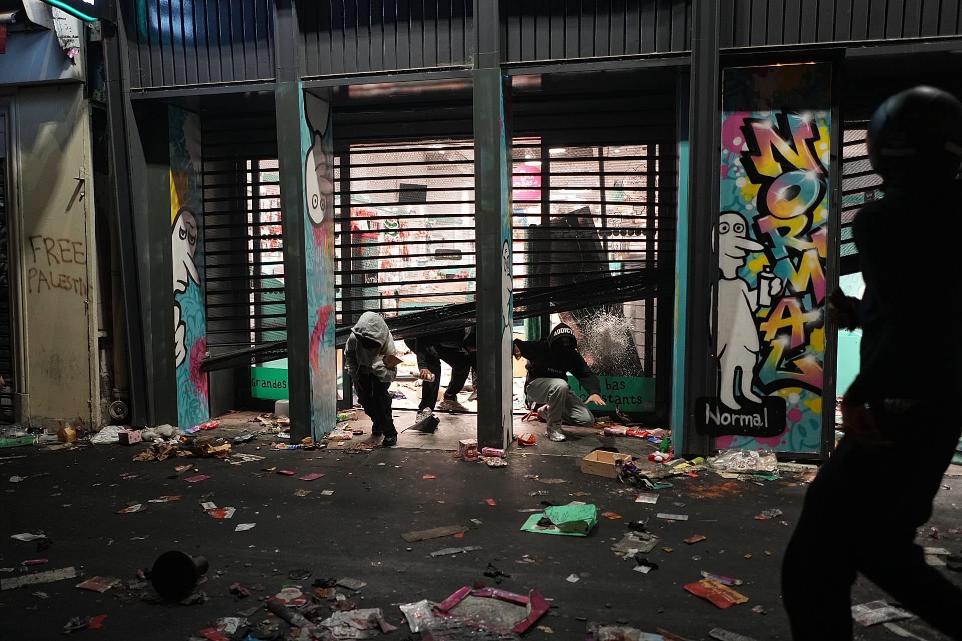 Protesters emerge from a looted store during a demonstration against rising living costs, joining students' grievances, in Paris, Saturday, Oct. 17, 2026.