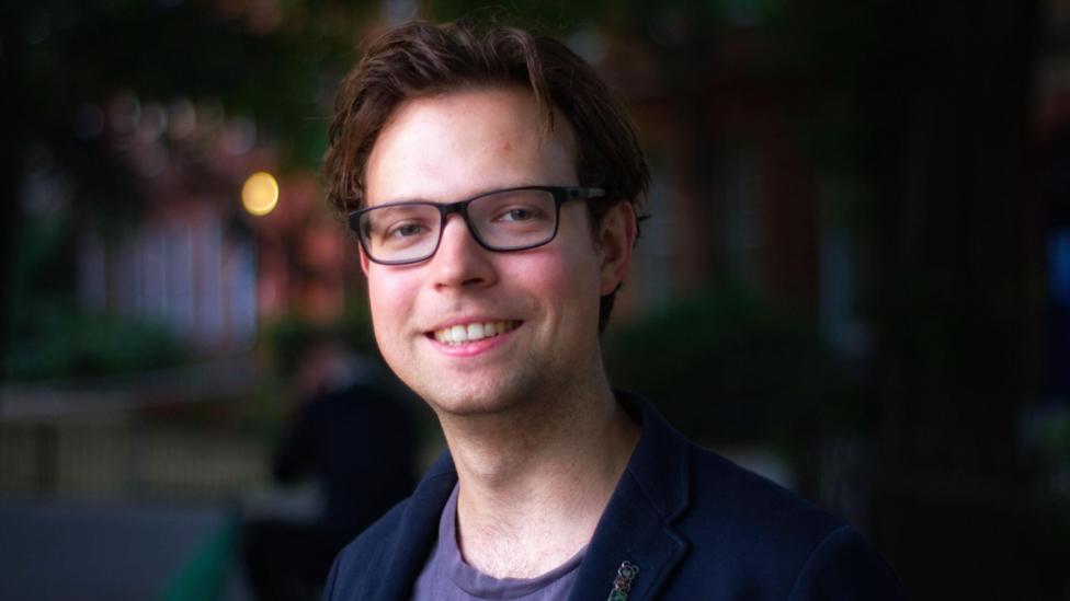 Andreas Kirsch has short dark hair and wears black-rimmed glasses.