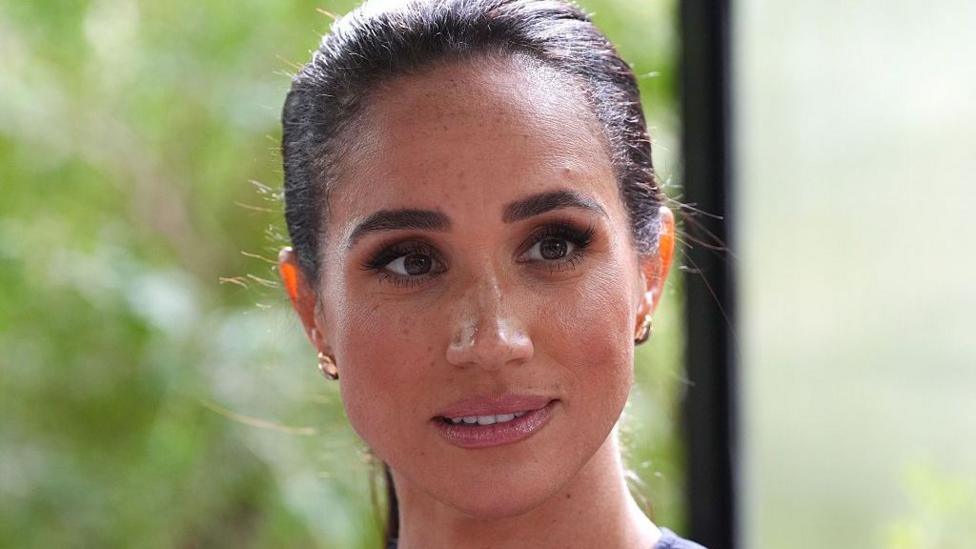Meghan Markle has a ponytail and brunette hair.