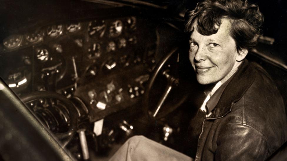 Amelia Earhart sitting in the cockpit of an Electra airplane