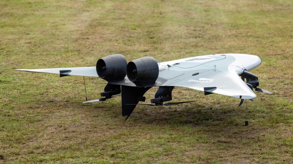 A Greenjets drone has a blended wing and fuselage with two enclosed motors on the upper side. Underneath the wing are four propellers.