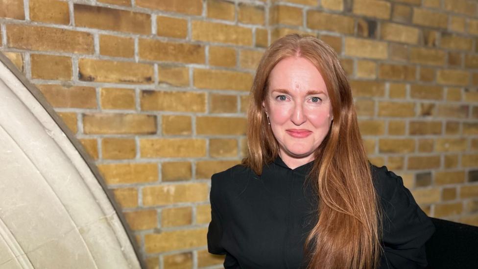 Mary Duggan with long hair wearing black at the award ceremony