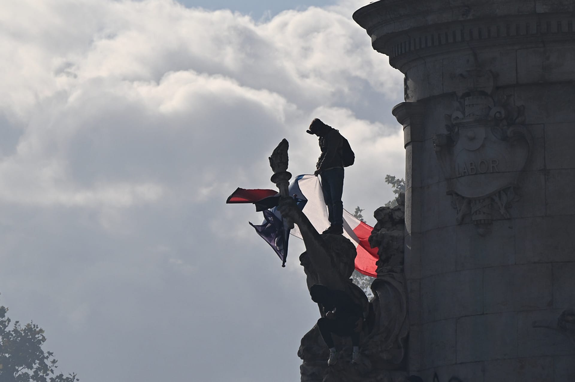 A protester stands with a French flag at the Republique plaza during a protest against rising living costs, in solidarity with students, Lyon, France, Saturday, Oct. 17, 2026