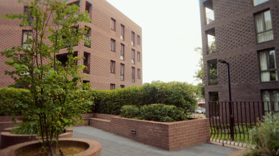 Low rise flats built with purple and pink bricks 