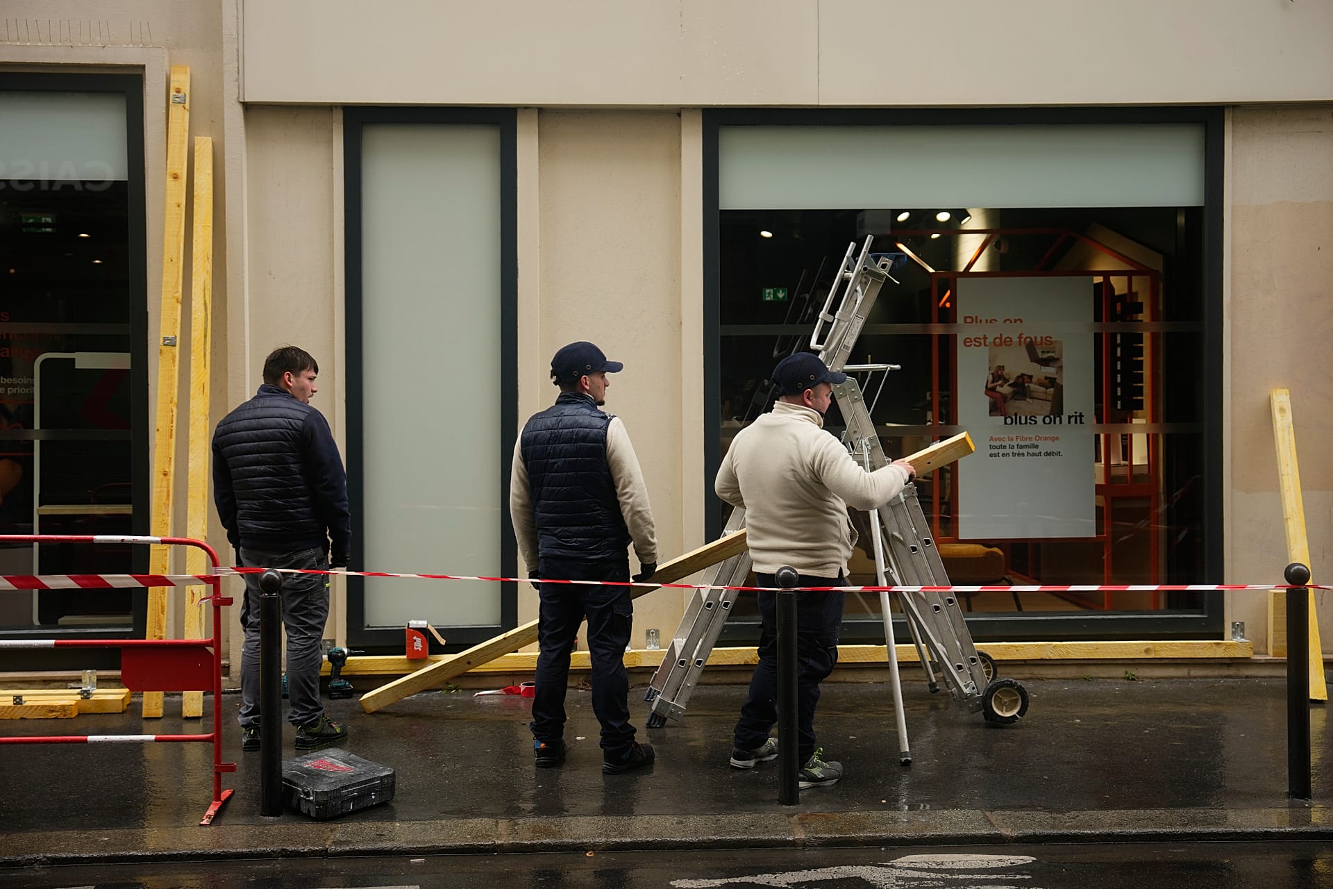 Workers board up a storefront on the eve of further protests in Paris, 23 Oct. 2026