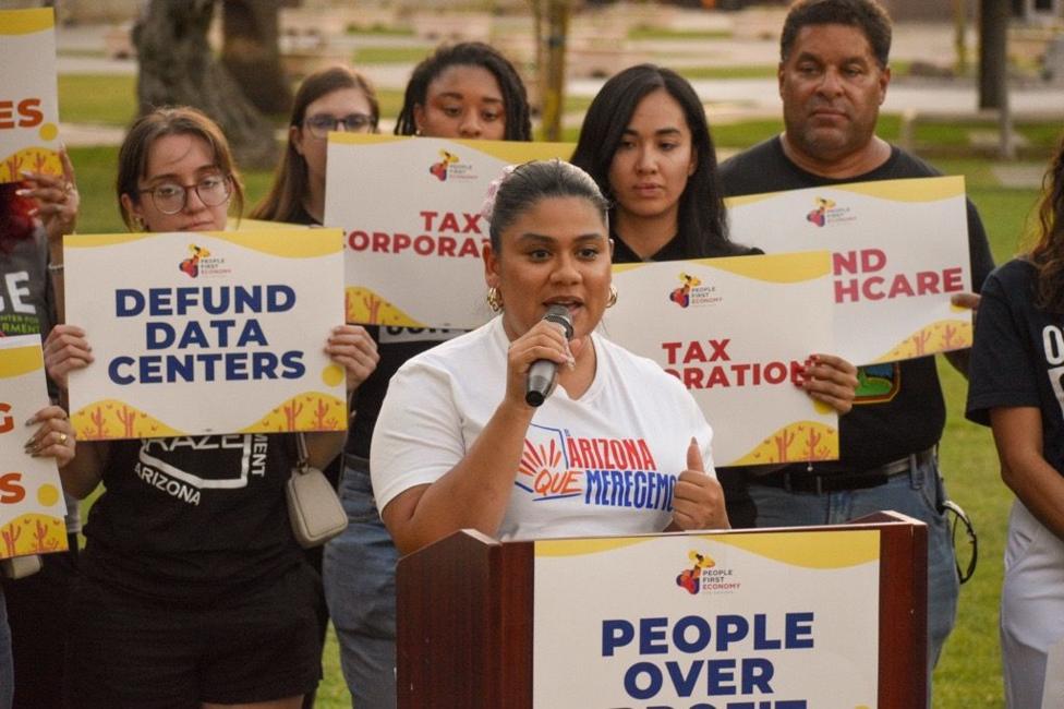 Stephanie Maldonado, the political director of LUCHA, speaks at a rally to stop data centres. She is surrounded by protestors holding signs that say "defund data centres"