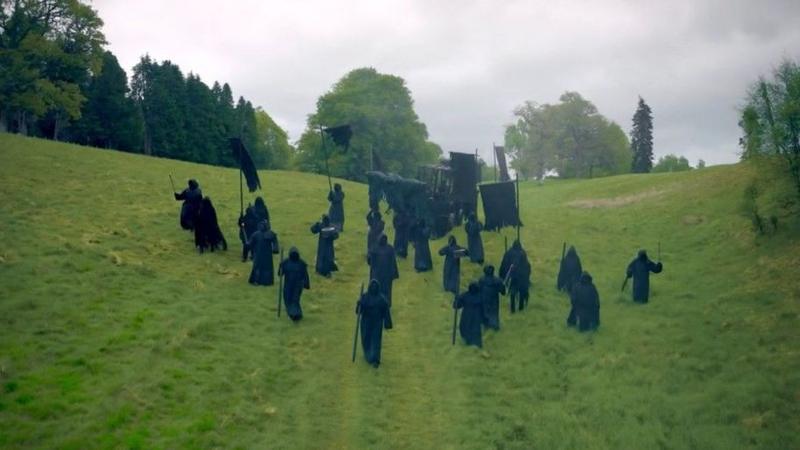 Death marchers on the approach to the forest in black cloaks