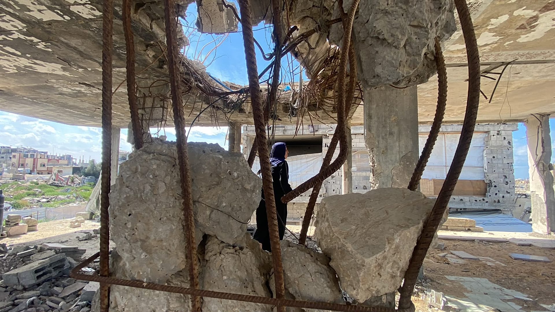 Mariam Abu Hazein, a Palestinian woman, on top of the rubble of her home in Al-Mughraqa, west of Gaza City
