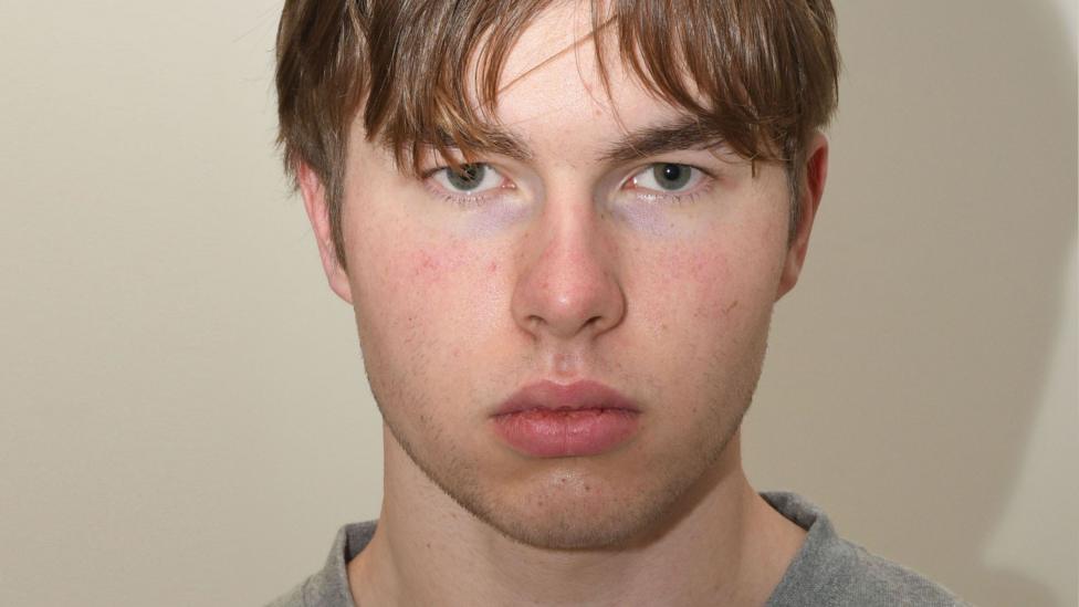 A mugshot of a young man staring at the camera.
